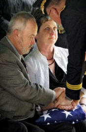 John and Dena Palmer are comforted following the graveside service for their son, U.S. Army Cpl. Eric Palmer of Maize, who died June 24 from wounds he received in combat in Iraq.